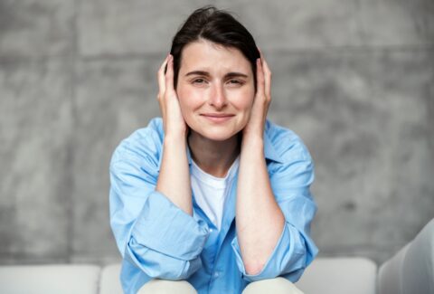 young,stressed,woman,wearing,casual,shirt,,sitting,on,couch,and